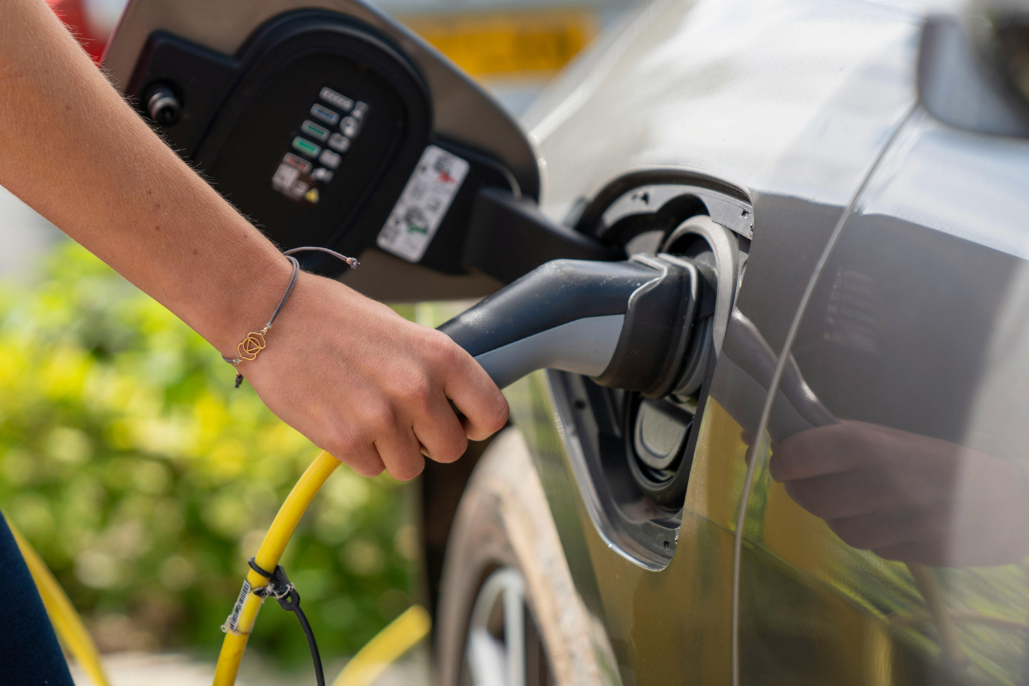 Woman charging an electric car at an EV charging station