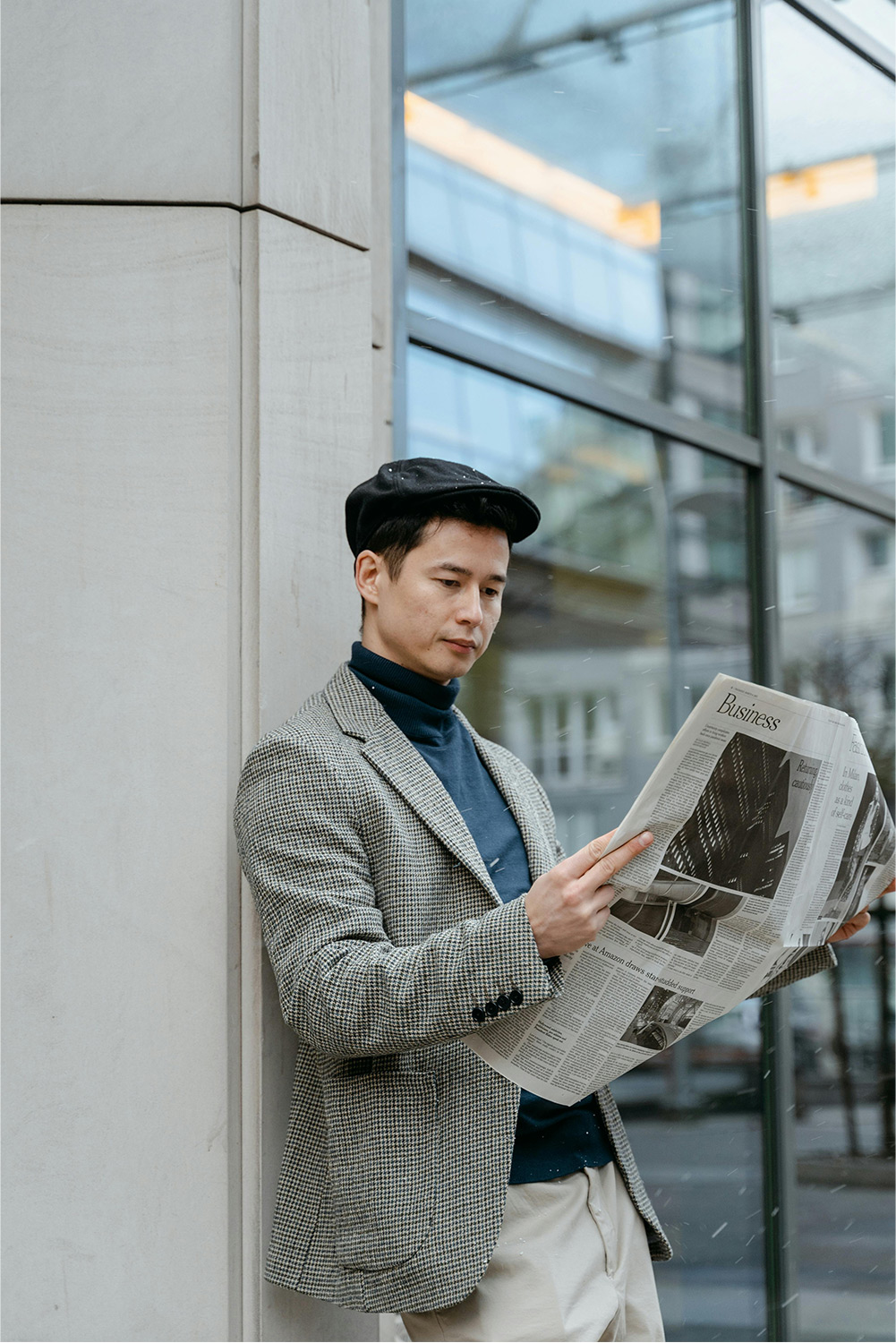 Business man reading newspaper in front of his office