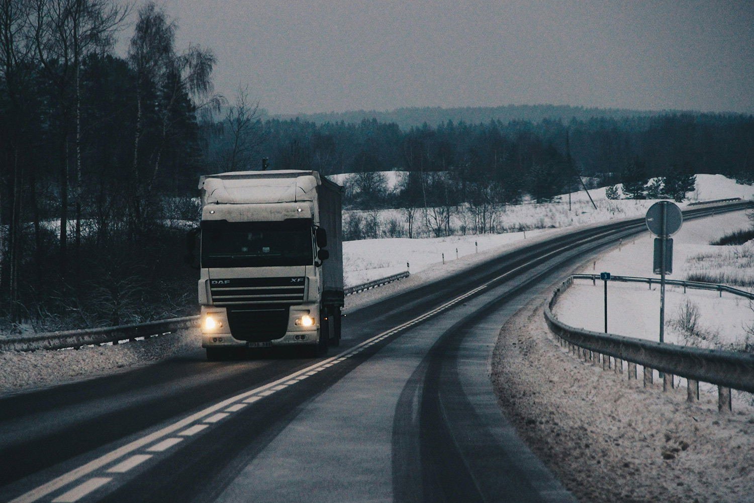 Truck on a road at night with snow